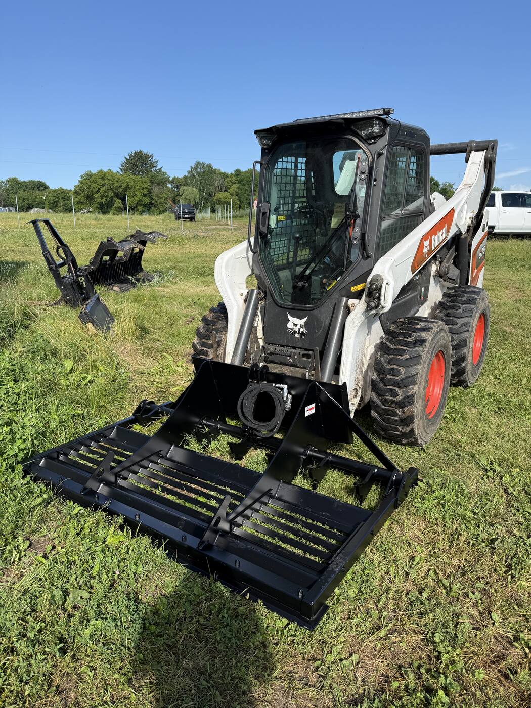 Our Bobcat skid loader with land leveler attachment — Revisions Unlimited equipment
