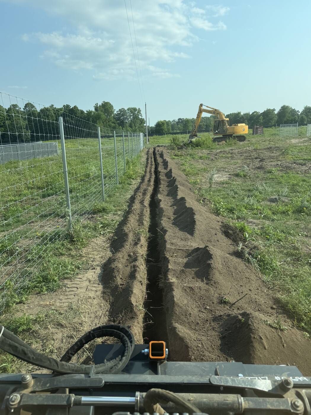 Open utility trench with spoil piled neatly alongside