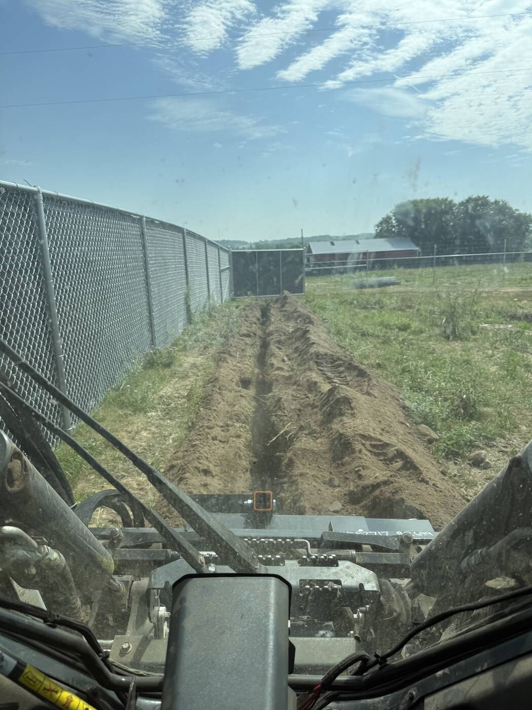 Trenching tight along a chain-link fence line