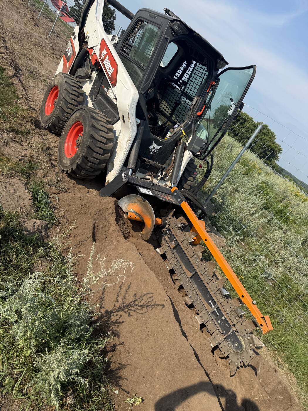 Trenching on a slope with the skid steer